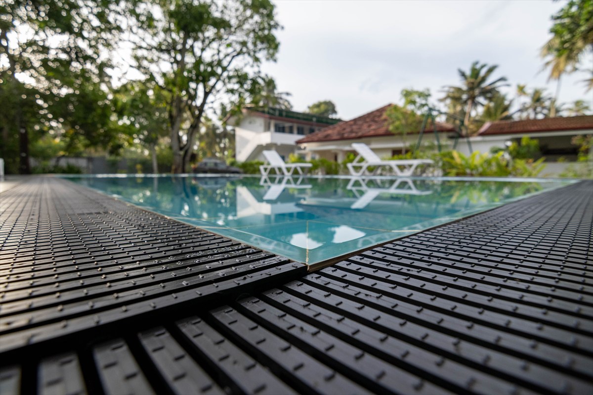 Poolside view of the shared swimming pool and sun loungers