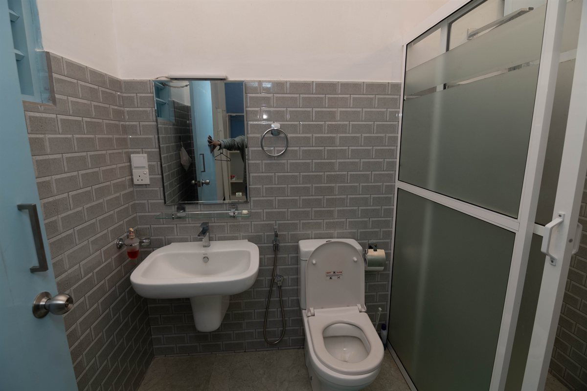Tropical Garden Retreat bathroom with basin, toilet and glass shower enclosure