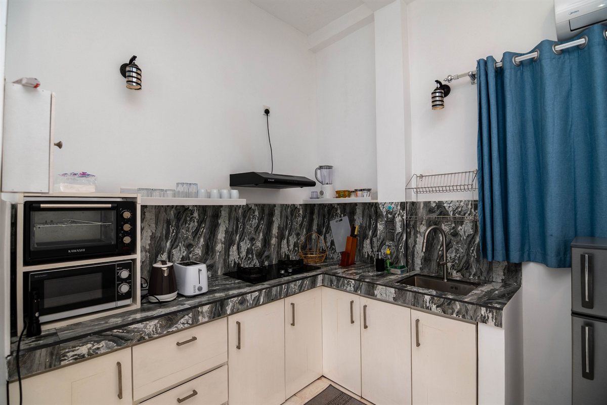 Private corner kitchen with a hob, oven and refrigerator at Tropical Garden Retreat