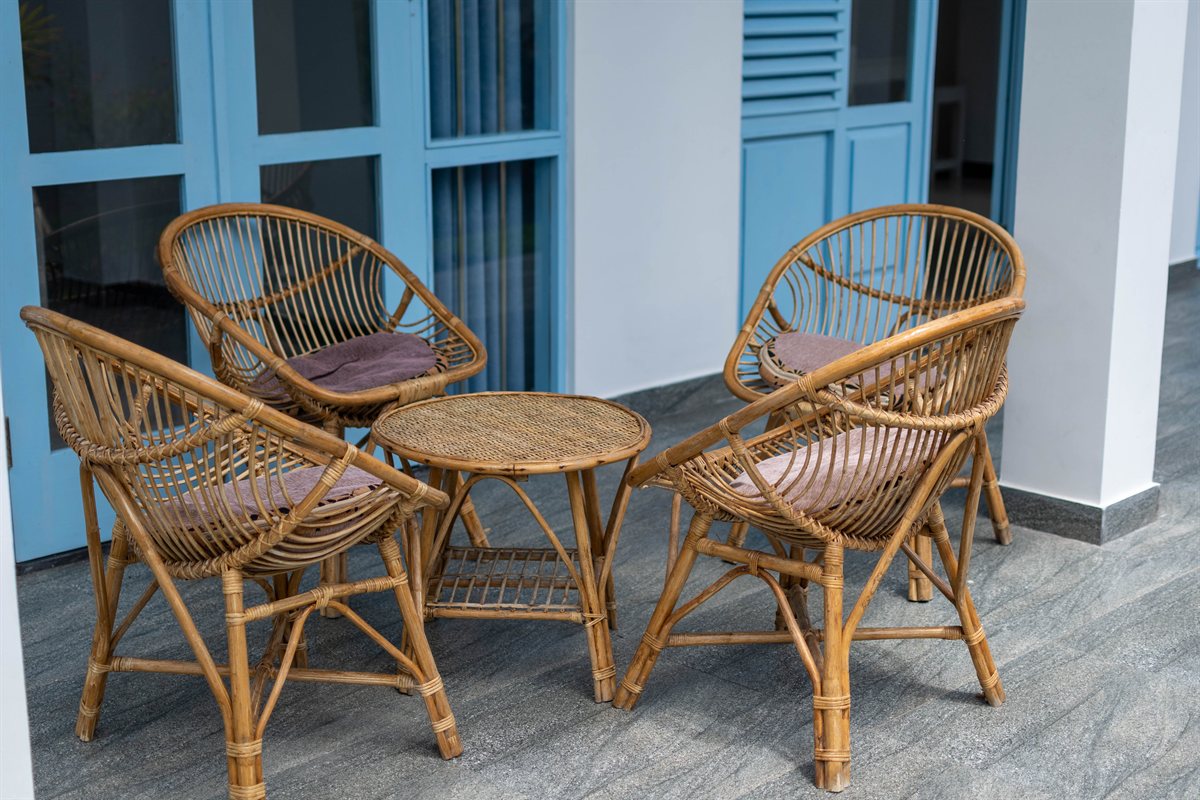 Rattan seating beside blue doors on the ground-floor porch at Tropical Garden Retreat
