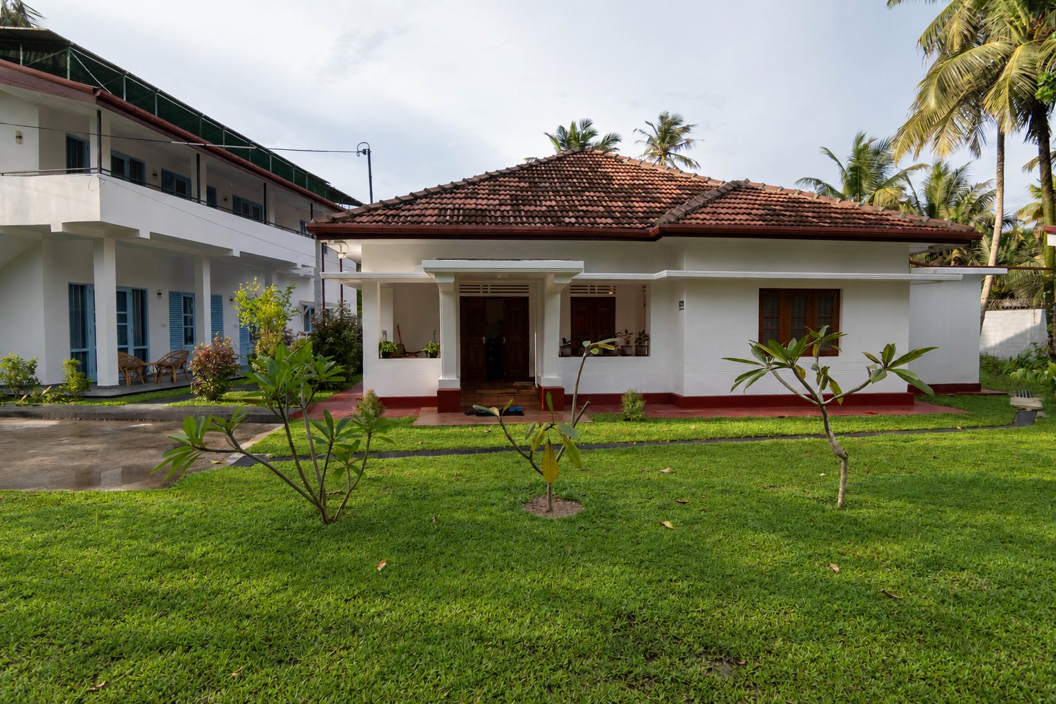 Heritage House across the green front lawn beside the two-storey villa at Dimuthu Ahangama