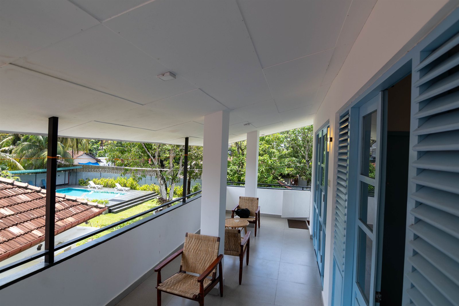 Upper-floor terrace with blue shutters and views over the garden at Tropical Palm View Retreat