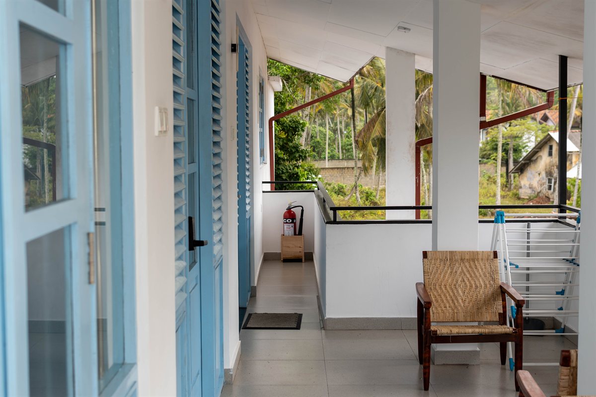 Seating and blue shutters along the upper-floor terrace at Tropical Palm View Retreat